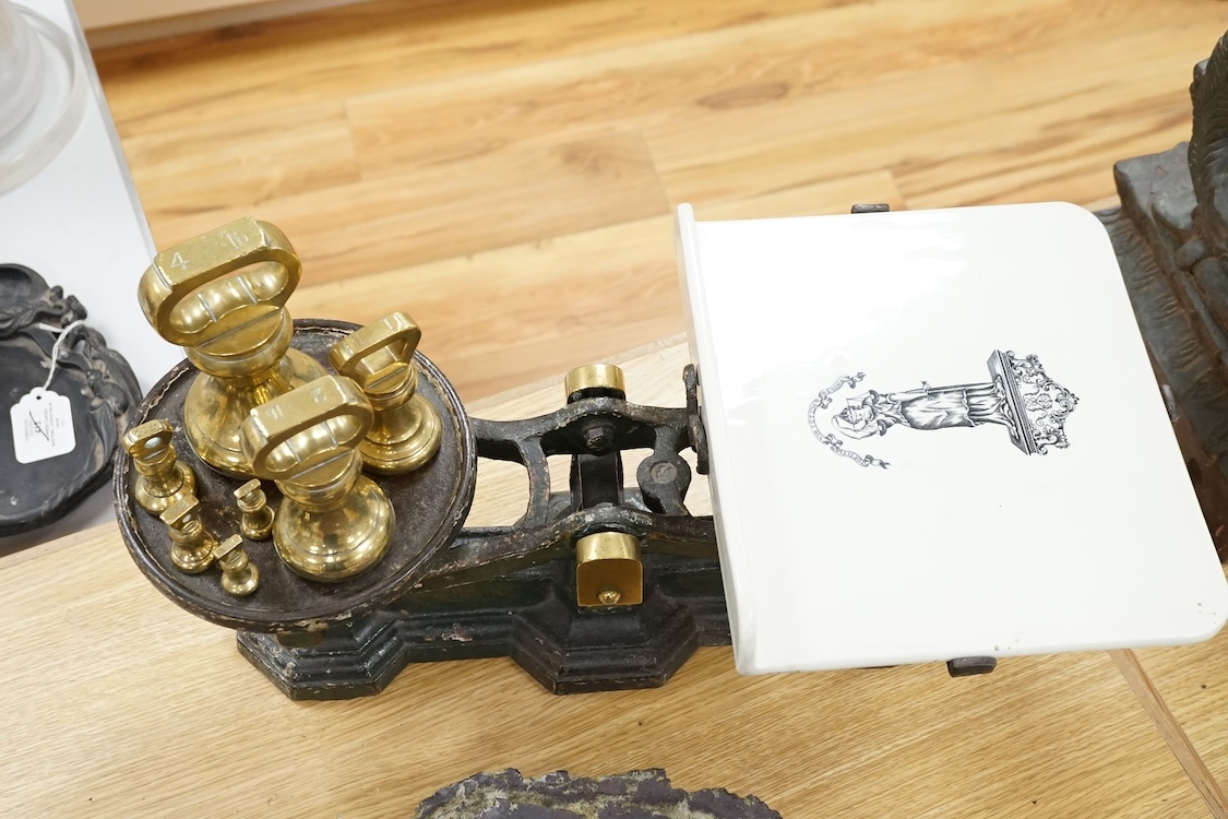 A set of Victorian iron and ceramic scales and seven brass weights, 53cm wide